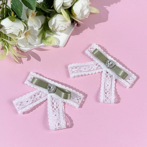 Detailed view of handmade lace bow hair clips with olive green ribbon and heart rhinestone