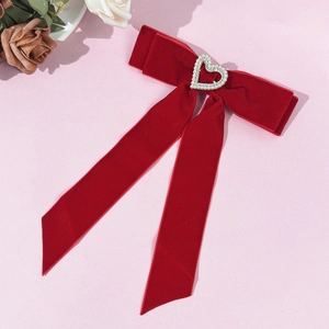 Eleganter roter Samt-Haarclip mit Perlenherz-Detail auf sanftem rosa Hintergrund