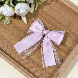 Roze Lolita haarstrik met kant en hartvormige strass op een houten dienblad
