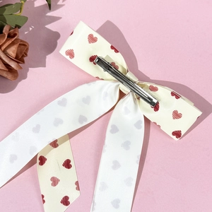 Sweet cream and white bow hair clip with red heart prints and a silver metal duckbill clip