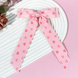 Detailed view of pink long ribbon hair clip with cute dark pink heart patterns