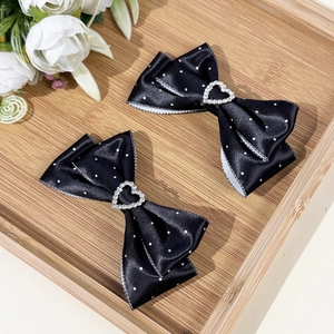 Par de pinzas para el cabello negras con lunares y pedrería en forma de corazón dulce