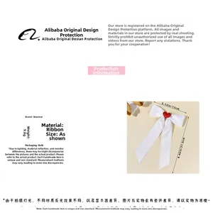 Detailed view of white ribbon bow hair clip with red heart centerpiece and dimensions