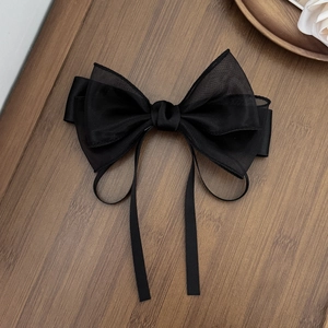 Detail view of large black organza mesh bow hair clip with elegant long ribbons