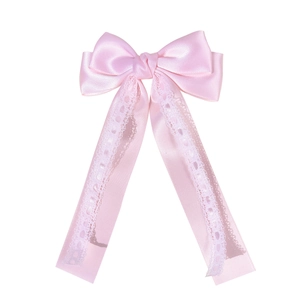 Pink satin bow hair clip with white wavy lace edges and long flowing ribbons