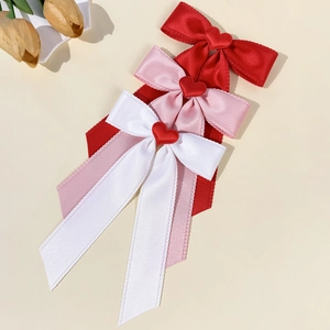 Three elegant heart ribbon bows in red, pink, and white satin for women's hair styling