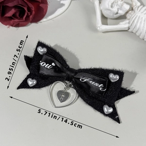 Detailed view of Gothic black bow hair clip with heart pearls and cross pendant details
