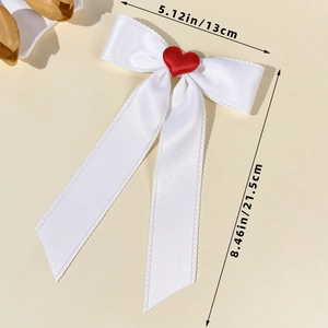 White satin bow hair clip with red heart detail and dimensions 5.12in by 8.46in