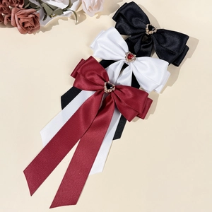 Three-piece set of satin bow hair clips with rhinestone hearts in black, white and red
