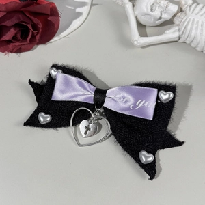 Detail of gothic bow hair clip with purple ribbon, plush fabric and heart charms