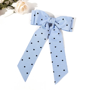 Detail of blue striped bow hair clip with heart print on textured grosgrain ribbon