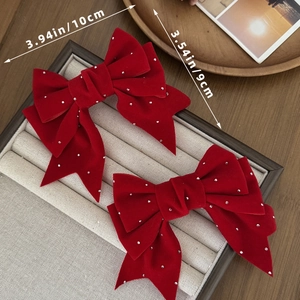 Detalle del lazo de terciopelo rojo con pedrería, dimensiones 10 cm por 9 cm