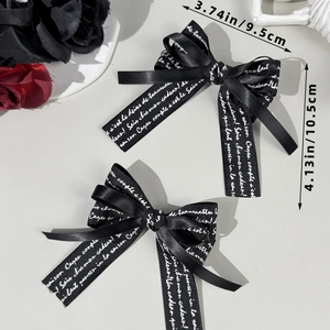 Set of two black gothic ribbon bow hair clips with white script text 9.5x10.5cm
