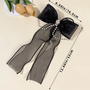 Détail du nœud papillon en résille noire avec chaînes de perles, dimensions 16,5x32 cm