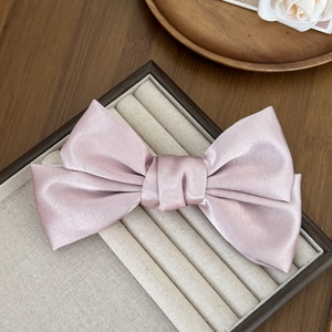Barrette à cheveux élégante en satin rose avec double nœud sur plateau en velours