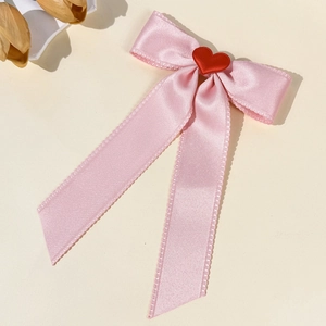 Elegant pink velvet bow hair clip with a red heart charm and satin sheen finish