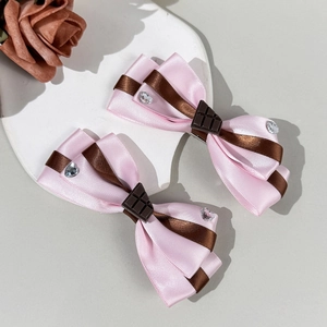 Dettaglio macro di fermagli per capelli Lolita con ciondoli al cioccolato e strass