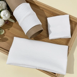 Close-up of white ribbed knit fabric texture on sports wristbands and headbands set
