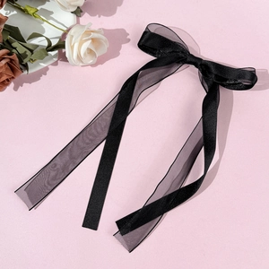 Detail of black satin and organza double-layered bow hair clip with elegant long ribbons