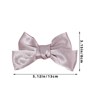 Detail view of purple satin bow hair clip measuring 13cm by 8cm with smooth silk texture