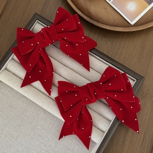 Detalle de pinzas de lazo de terciopelo rojo con strass brillantes en expositor