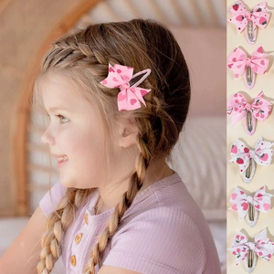 Detail showing set of six bow hair clips with strawberry and cherry patterns for girls