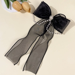 Détail d'un nœud papillon en tulle noir avec chaînes de perles et cristaux de style français