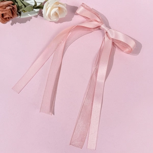 Detail view of pink ballet bow hair clip with satin ribbon and organza texture