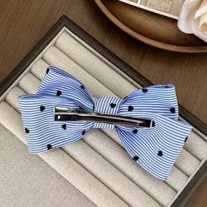 Barrette nœud à rayures bleues et blanches avec cœurs noirs sur plateau en velours