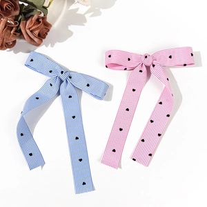 Striped bow hair clips with heart patterns and ribbons in pink and blue colors