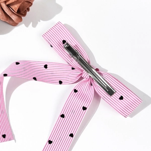 Pink and white striped bow hair clip with black hearts and silver metal alligator clip