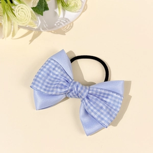 Blue plaid bow hair tie with double-layer ribbon design on an elegant cream background