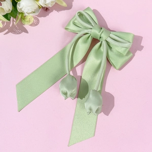 Vue détaillée du nœud en satin vert clair avec des pendentifs élégants en forme de tulipe