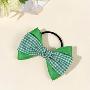 Detail of green plaid and satin double layered bow hair scrunchie with elastic band