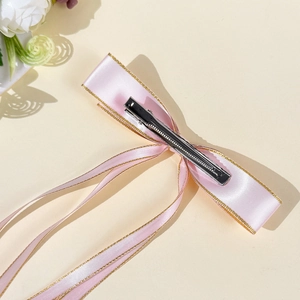 Fiocco per capelli in raso rosa con bordo dorato e fermaglio a coccodrillo in metallo, retro