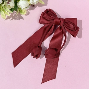 Détail d'un nœud papillon en satin bordeaux avec d'élégants pendentifs tulipes faits main