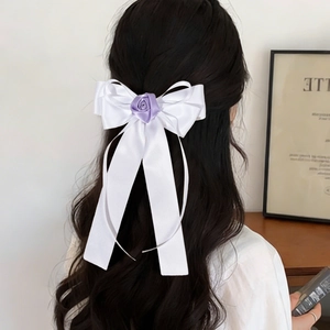 Détail de la barrette nœud en satin blanc avec rose violette et longs rubans