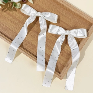 Paire de barrettes à nœud en satin blanc à pois noirs avec de longs rubans fluides