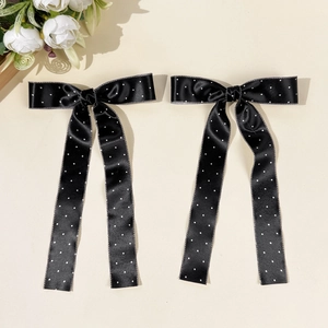 Détail de nœuds à cheveux en satin à pois blancs avec de longs rubans fluides
