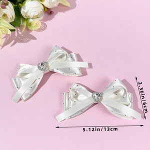 Detailed view of white polka dot satin bow hair clips with heart rhinestone center, 13x6cm