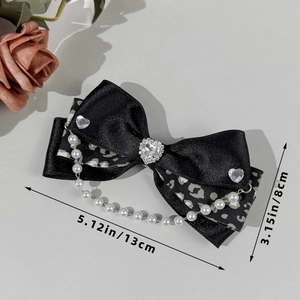 Détail de la pince à cheveux avec nœud léopard, strass en cœur et chaîne de perles de 13cm