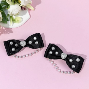 Vue détaillée des barrettes nœuds Lolita avec perles, strass en cœur et glands élégants