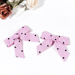 Détail de nœuds à cheveux Lolita rayés rose et blanc avec motifs de cœurs noirs