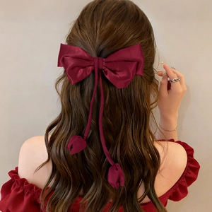 Detailed back view of a burgundy satin bow hair clip with elegant tulip charm streamers