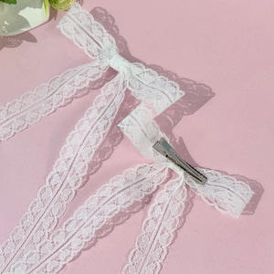 Barrette à cheveux élégante en dentelle blanche avec de longs rubans sur fond rose