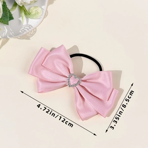 Pink satin bow hair scrunchie with rhinestone heart on a minimal beige background