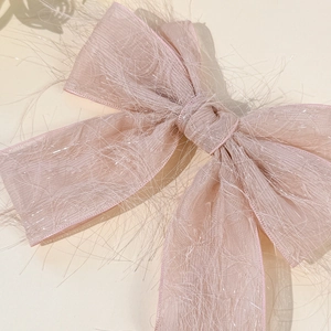 Gros plan détaillé d'un nœud papillon en organza rose avec fibres métalliques