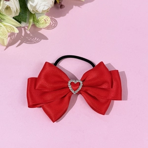 Red silk bow hair scrunchie with heart rhinestone detail on sweet pink background