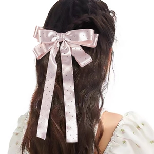 Vue détaillée de dos d'une pince à cheveux en satin rose pâle à pois avec rubans