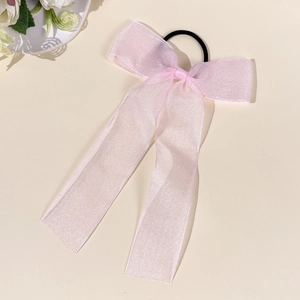 Close-up of pink organza mesh bow hair tie with long ribbons and elastic black band